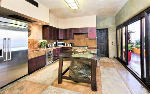 a kitchen with a glass table and a refrigerator at NEW Luxury Getaway - Pool, Spa, Sunset, VIEWS @ Casa Bella in Todos Santos