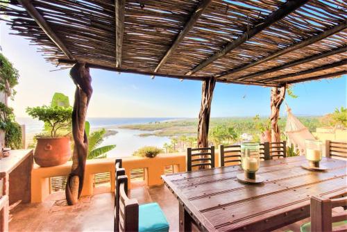 a wooden table on a balcony with a view of the ocean at NEW Luxury Getaway - Pool, Spa, Sunset, VIEWS @ Casa Bella in Todos Santos