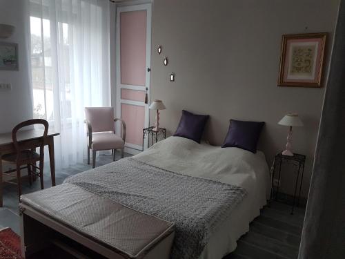 1 dormitorio con 1 cama grande con almohadas moradas en Lecerf en Condé-sur-Noireau