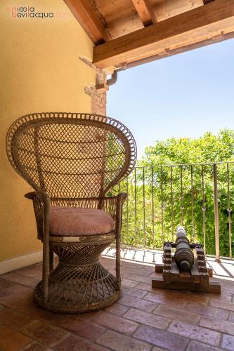 a wicker chair sitting on a porch next to a fence at B&B in Valle in Lumignano
