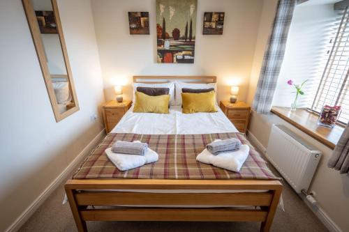 a bedroom with a bed with two towels on it at Cliff Walk Cottage in Arbroath