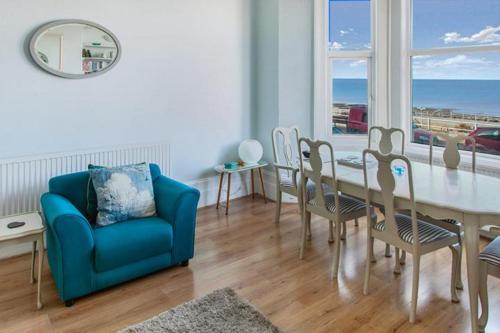 a dining room with a blue couch and a table and chairs at Margate Seascape Retreat in Margate