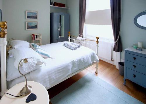 a bedroom with a white bed and a window at Margate Seascape Retreat in Margate