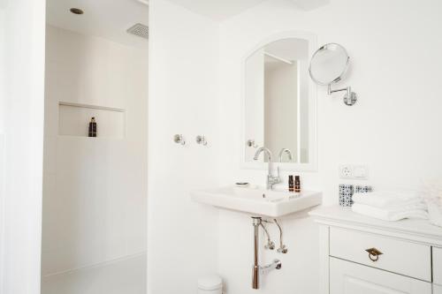Baño blanco con lavabo y espejo en Krone Martinsthal en Eltville