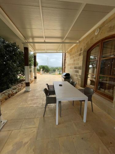 a white table and chairs on a patio at SAN MARTIN WELLNESS RETREAT (Upper) in Il-Palma