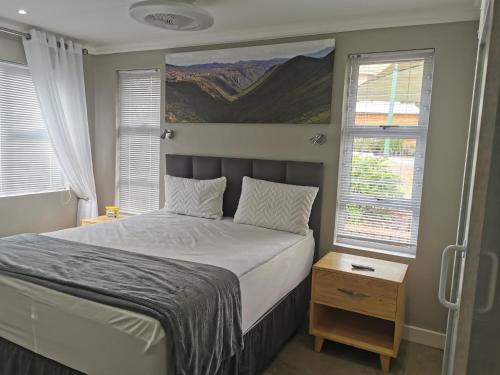 - une chambre avec un lit et 2 fenêtres dans l'établissement SiriMiri Cottage Dullstroom No Loadshedding, à Dullstroom