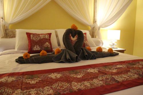 a stuffed swan on a bed in a bedroom at TAMAN EDEN COTTAGE in Ubud