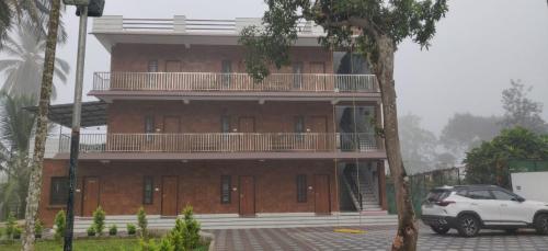 a building with a car parked in front of it at DOLPHIN ENCLAVE SERVICE STUDIO APARTMENTS in Kalpetta