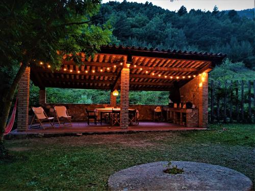 a wooden pergola with a table and chairs under it at Molí de Dalt in La Coma i la Pedra