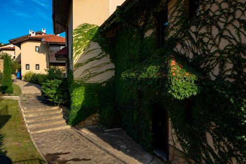 a building with green ivy on the side of it at Menada Sunny Hill Villa in Kosharitsa