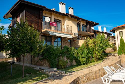 a building with chairs in front of it at Menada Sunny Hill Villa in Kosharitsa