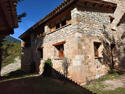 an old stone building with windows on the side of it at Molí de Dalt in La Coma i la Pedra