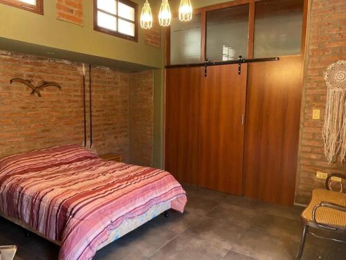 a bedroom with a bed and a brick wall at Casa calle Paula in San Juan
