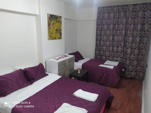 two beds in a room with purple sheets at Üsküdar halk caddesi in Istanbul