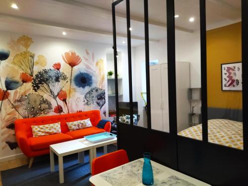 un salon avec un canapé orange et une chambre dans l'établissement Studio Top, à Perros-Guirec