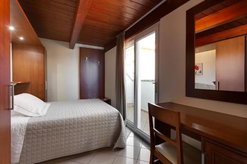 a bedroom with a bed and a large window at Hotel Dolcevita in Cesenatico