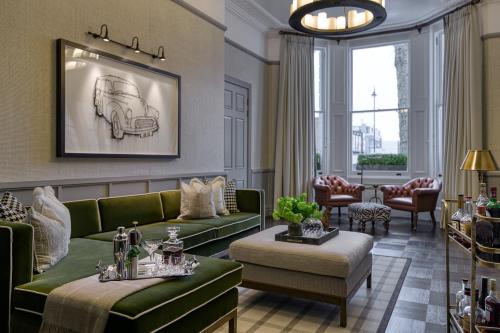 a living room with green couches and a table at The Adria in London