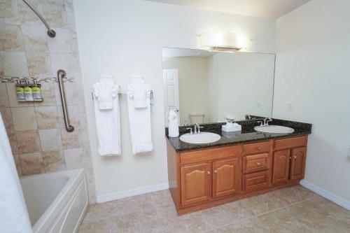 a bathroom with two sinks and a tub and a mirror at Holiday Inn Resort Grand Cayman by IHG in George Town