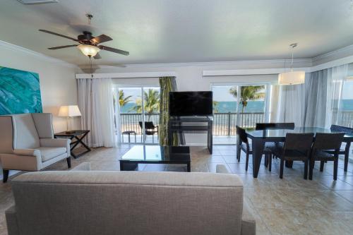 a living room with a couch and a table with a piano at Holiday Inn Resort Grand Cayman by IHG in George Town