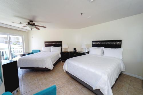 a bedroom with two beds and a ceiling fan at Holiday Inn Resort Grand Cayman by IHG in George Town