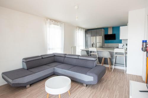 un salon avec un canapé et une cuisine dans l'établissement Appartements de 2 ou 3 chambres à 40 minutes de Paris, Évry-Courcouronnes