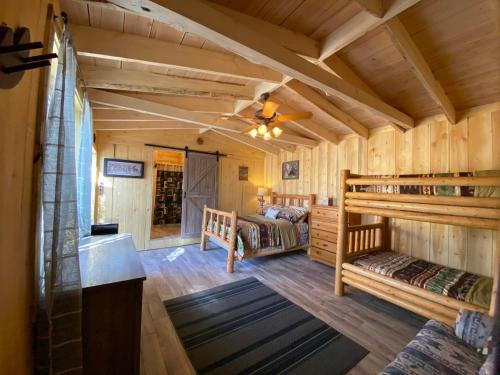 Cabaña de madera con 2 camas y ventilador de techo en Yellowstone Cutthroat Guest Ranch, en Wapiti