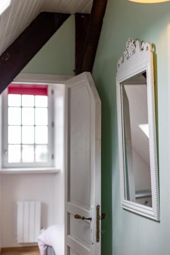 un miroir sur un mur à côté d'une porte dans l'établissement joli appartement 2 pers dans les remparts de Guérande, à Guérande