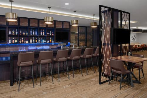 a bar with chairs and a television in a room at Holiday Inn Hasbrouck Heights-Meadowlands by IHG in Hasbrouck Heights
