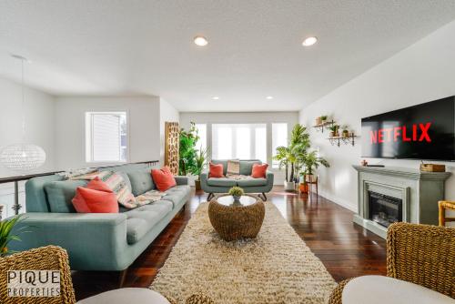 a living room with a couch and a fireplace at Tropical Oasis - King Beds - Free Netflix & Parking - Fast Wi-Fi in Edmonton