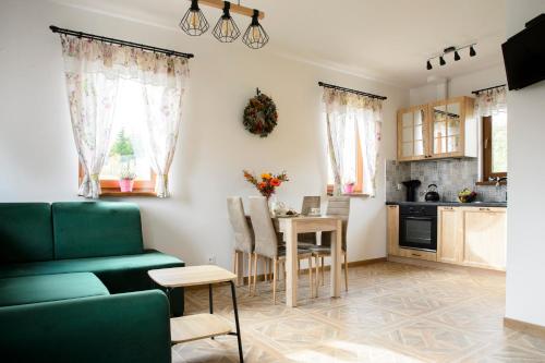 a living room with a green couch and a table at Słoneczna Chałupka in Zawoja