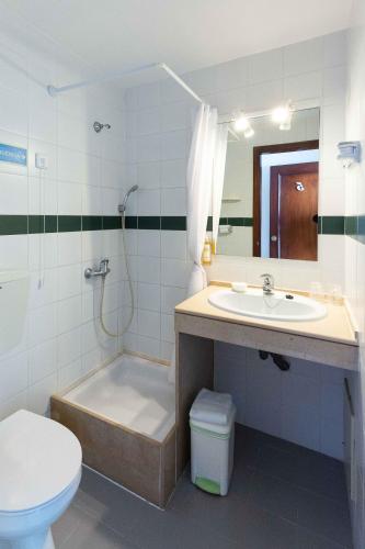 a bathroom with a tub and a sink and a toilet at Villa Marquez in Vila Real de Santo António