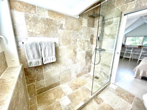 Un baño con ducha con puerta de cristal en Blue Dream 3 à 5 chambres villa sur la plage, en Baie Nettle