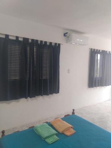 a bedroom with a bed with two towels on it at Atardecer Serrano in Huerta Grande