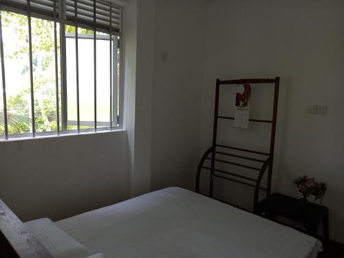 a bedroom with a bed and a window at BAWANS VILLA Holiday Home for Family or Group in Hikkaduwa