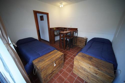 a room with two beds and a desk and a table at Magna in El Chalten