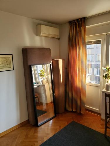 a mirror in a living room with a window at Cozy room in appartment, with shared bathroom,downtown Belgrade in Belgrade