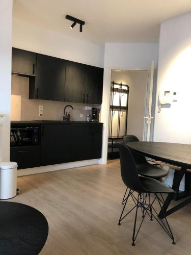 a kitchen and dining room with a table and chairs at CONDO Romain in Nieuwpoort