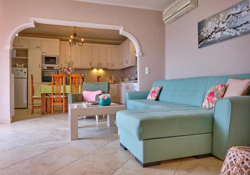 a living room with a blue couch and a table at Villa Meli Afionas Corfu in Afionas