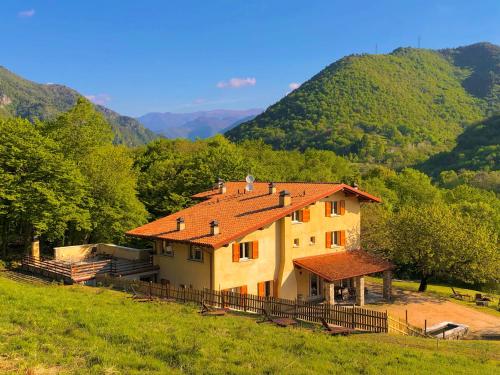dom na wzgórzu z górami w tle w obiekcie Agriturismo San Lorenzo di Persegno w mieście Toscolano Maderno