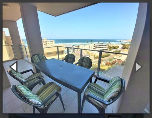 a balcony with a table and chairs and the beach at 201 St Tropez, South Coast in Margate