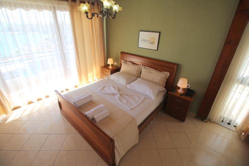 a bedroom with a large bed with white sheets and pillows at Olympia Hotel in Sarandë