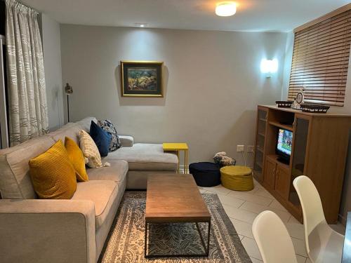 a living room with a couch and a tv at 201 St Tropez, South Coast in Margate