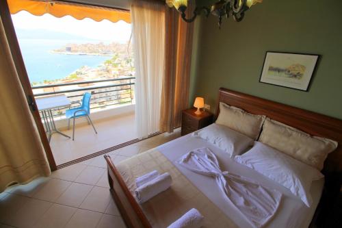 a bedroom with a bed with a view of the ocean at Olympia Hotel in Sarandë