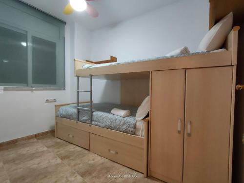 a bedroom with bunk beds and a large window at LG Calafell Beach in Calafell