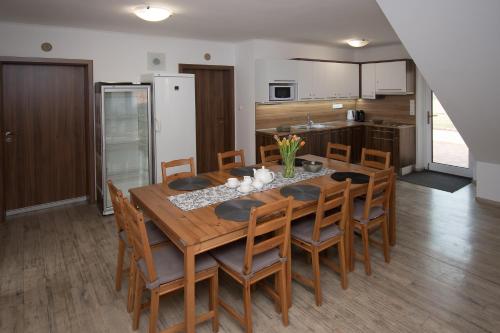 a kitchen and dining room with a wooden table and chairs at penzion U Hrnčíře in Hnanice