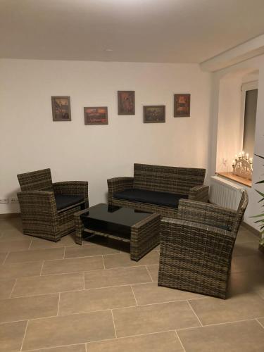 a living room with wicker chairs and a couch at Neue Unterkunft mit Kamin im Erzgebirge - SZB in Neuanbau