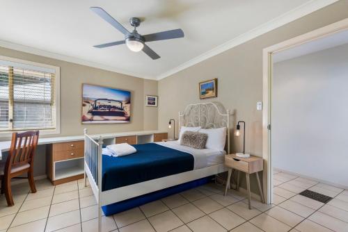 a bedroom with a bed and a ceiling fan at Frangipani Hideaway in Lennox Head