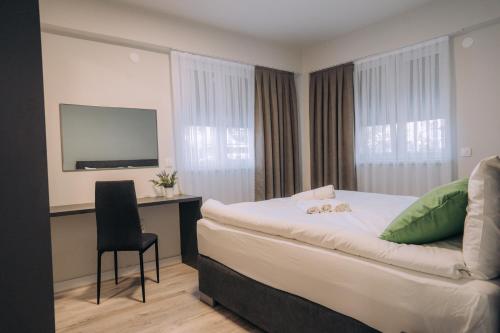 a hotel room with a bed and a desk and a television at Bellissimo Apartments in Ohrid