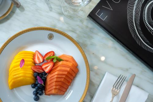 a plate of food with fruit on a table at Alvear Palace Hotel - Leading Hotels of the World in Buenos Aires