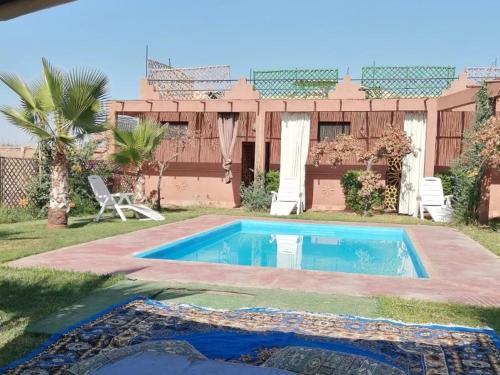 a swimming pool in the yard of a house at Riad Darga Rouge in Marrakesh